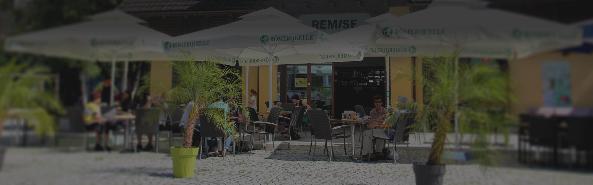 Café Remise Bludenz – Terrasse mit Sonnenschirmen am Raiffeisenplatz